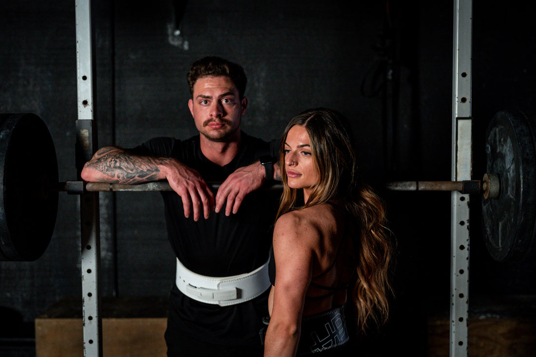 woman and man standing in front of barbell