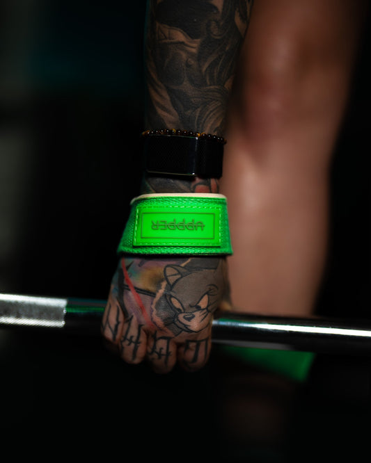 woman gripping barbell wearing uppper lifting straps