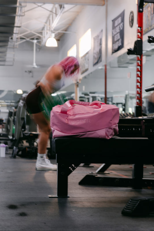 woman walking around with pink gym bag uppper