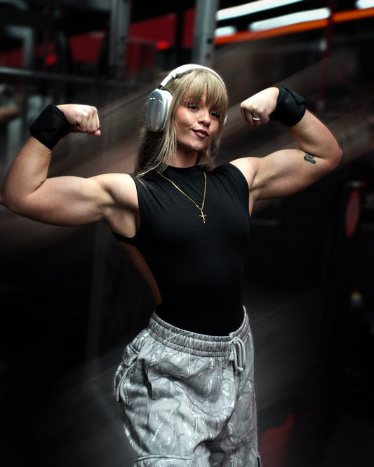 woman flexing biceps and wearing uppper wrist wraps