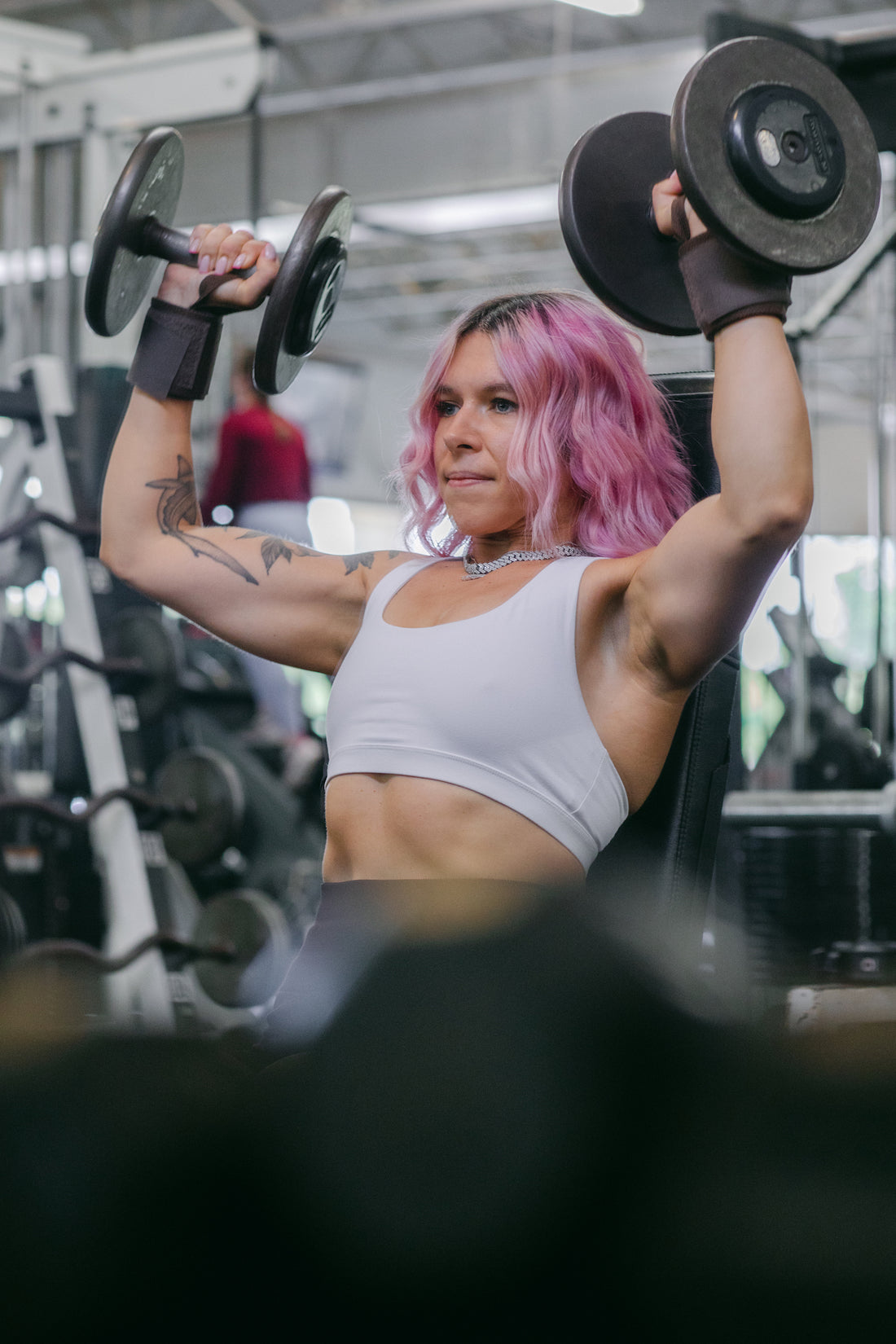 woman doing shoulder presses with uppper wrist wraps